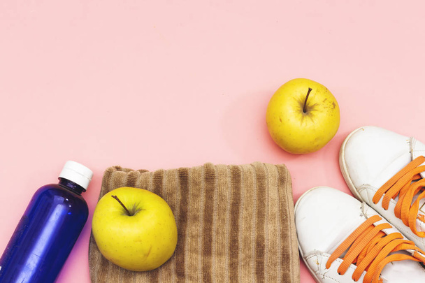 Sports equipment flat lay,  yellow apples and water bottle, sneakers. Concept healthy lifestyle, sport and diet. - Photo, Image