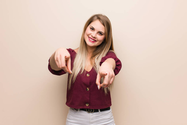 Young russian woman cheerful and smiling pointing to front - Photo, Image