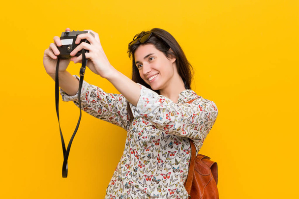 Young caucasian woman holding a vintage camera - Фото, изображение