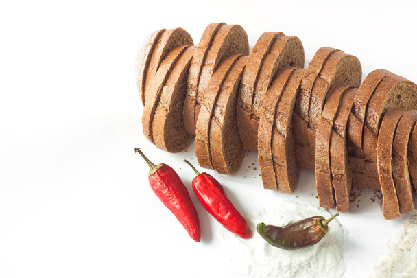 Roggebrood met rode chili pepers en zout op een witte achtergrond geïsoleerd. - Foto, afbeelding