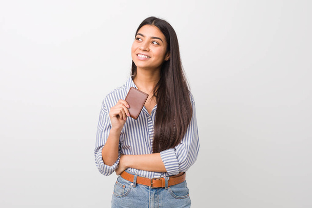 Young arab woman holding a wallet smiling confident with crossed arms. - Photo, Image