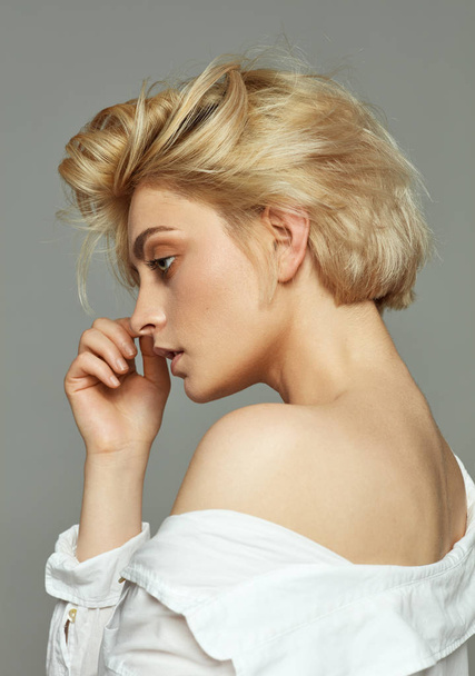 Portrait of blonde woman with short hair wearing white shirt - 写真・画像