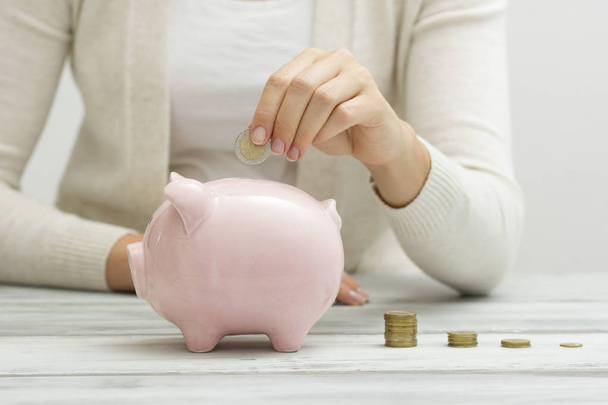 woman hand putting money coin into piggy for saving money wealth and financial concept - Фото, зображення