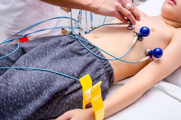 Enfermeira está preparando uma criança, paciente adolescente para ECG ou teste de ECG
 - Foto, Imagem