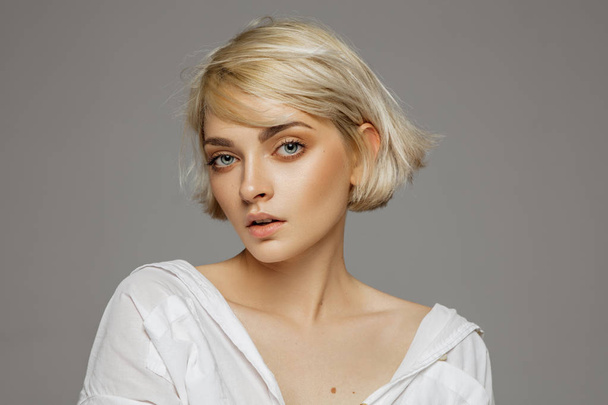 Portrait of blonde woman with short hair wearing white shirt - Zdjęcie, obraz