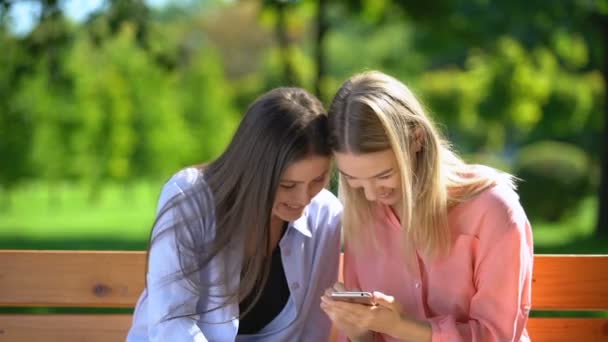 Two funny female friends scrolling and discussing photos of men in dating app - Πλάνα, βίντεο