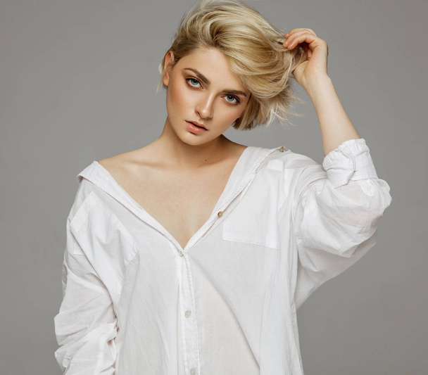 Portrait of blonde woman with short hair wearing white shirt - Фото, изображение