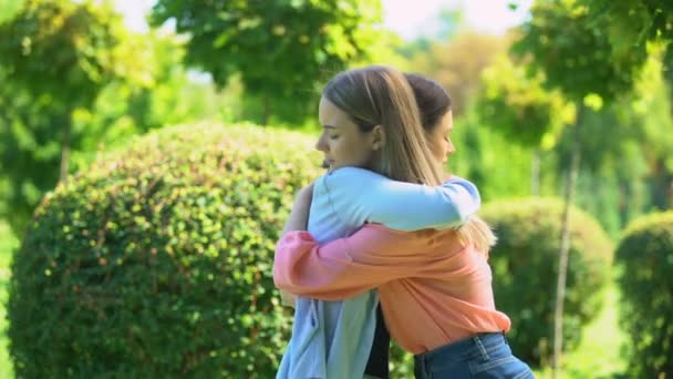 Two women hugging outdoor, saying good-bye, friendship, trusting relationship - Filmati, video