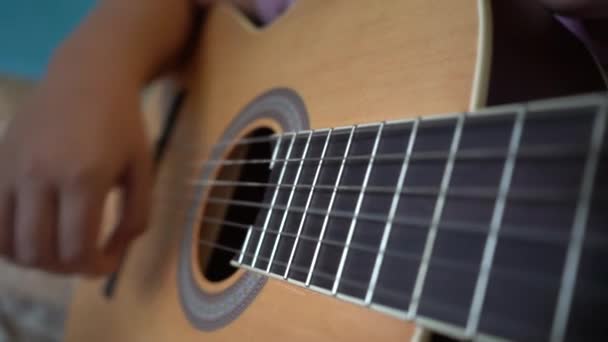 As crianças aprendem a tocar guitarra. Close-up de uma guitarra e cordas com as mãos das crianças
. - Filmagem, Vídeo