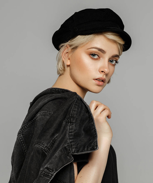 Fashion portrait of young blonde woman in black denim jacket and hat - Fotoğraf, Görsel