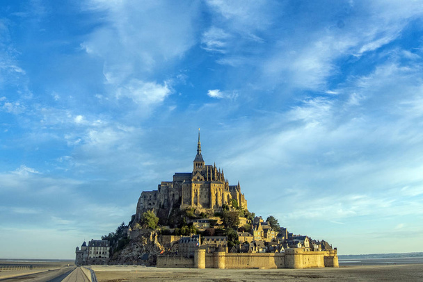 Dawn in Mont Saint Michel and its abbey with the sea at low tide - Photo, Image