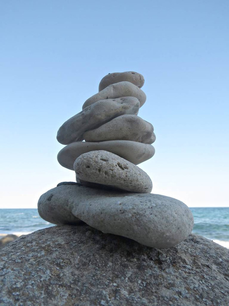 Zen kivi cairn lähellä merta. Harmonia ja tasapaino käsite. Yksinkertaisia pikkukiviä, kivitorni. Ranta kivet pino
. - Valokuva, kuva