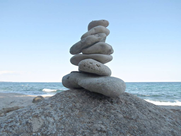 Harmony, balance and simplicity concept. A stone tower on the sea background. Simple poise pebbles, rock zen sculpture. - Photo, Image