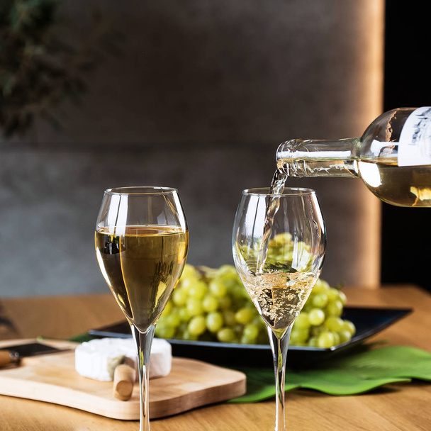 Primo piano di versare vino bianco nel ristorante
 - Foto, immagini