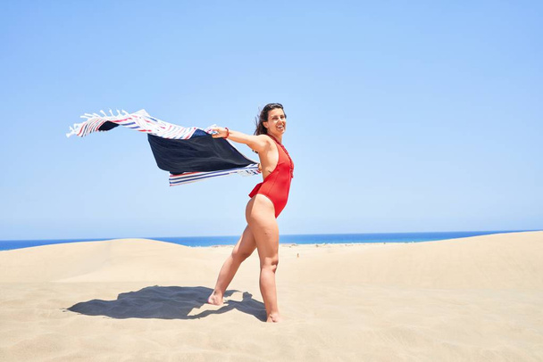 Молода красива жінка купається з відкритими руками, тримаючи рушник на маспаломах дюни буряк
 - Фото, зображення