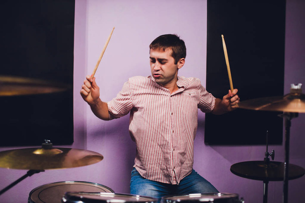 Young man behind drum-type installation in a professional recording studio. - Fotó, kép