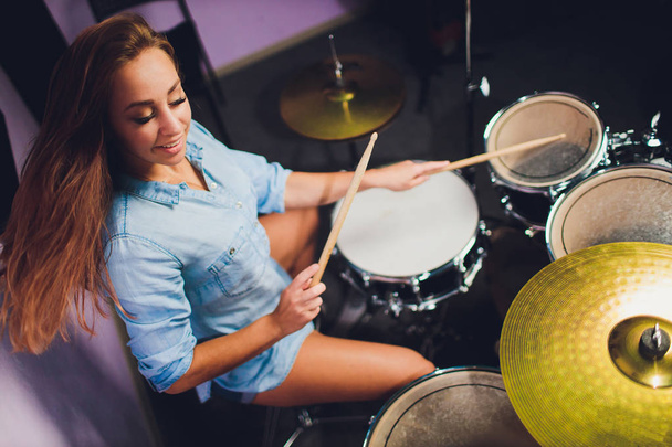 Photograph of a female drummer playing a drum set on stage. - Fotografie, Obrázek