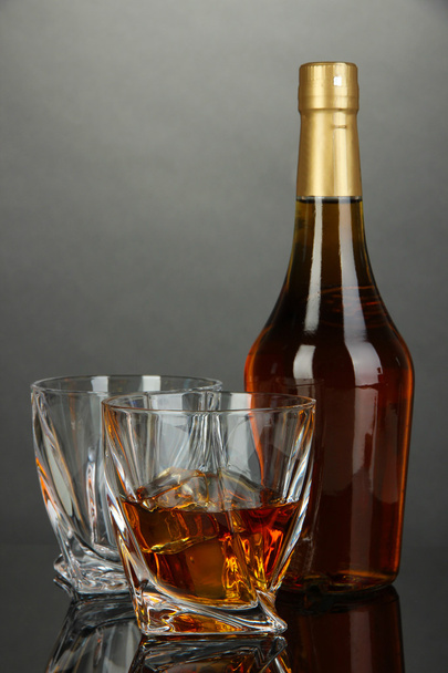 Glass of whiskey with bottle, on dark background - Photo, Image