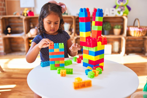 Красива дівчинка-малюк грає з будівельними блоками в дитячому саду
 - Фото, зображення
