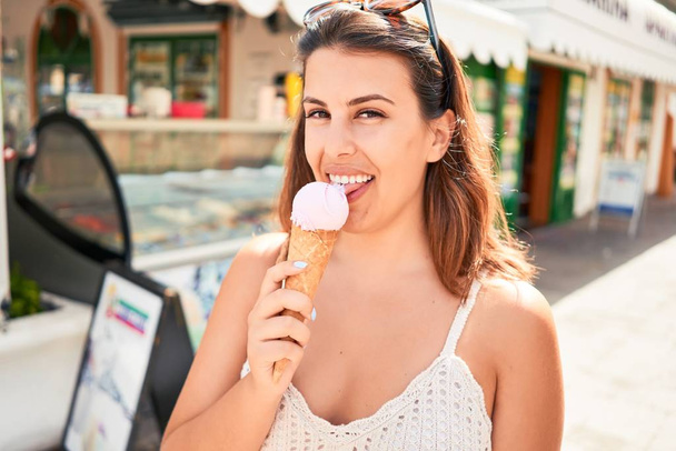 Mladá krásná žena jíst zmrzlinu kužel na bledost na slunný letní den na dovolenou - Fotografie, Obrázek