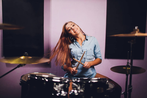 Photograph of a female drummer playing a drum set on stage. - Fotografie, Obrázek