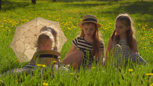 Cuatro chicas están sentadas en el jardín y leyendo
 - Imágenes, Vídeo