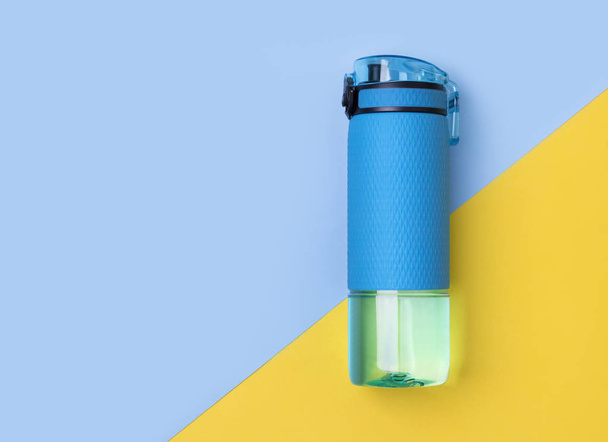 Blue bottle of water. Sport beverage on creative background. - Photo, Image