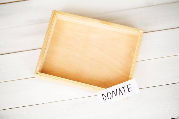 Donate conception. Box with money on white wood background - Fotó, kép
