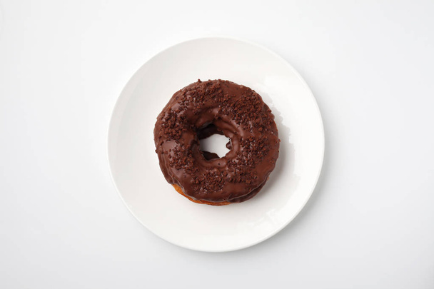 chocolate frosted doughnut on plate isolated on white background - Fotografie, Obrázek