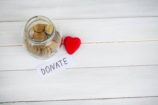 Spenden Sie! Glas mit Geld auf weißem Holz Hintergrund - Foto, Bild