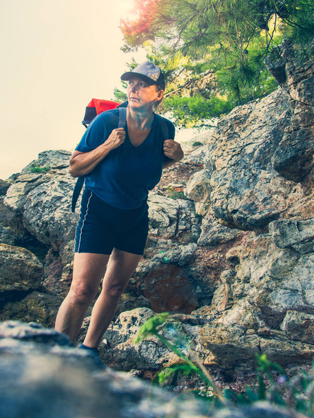 Trekking in Croatia. A mature woman standing on the edge of a cl - Φωτογραφία, εικόνα