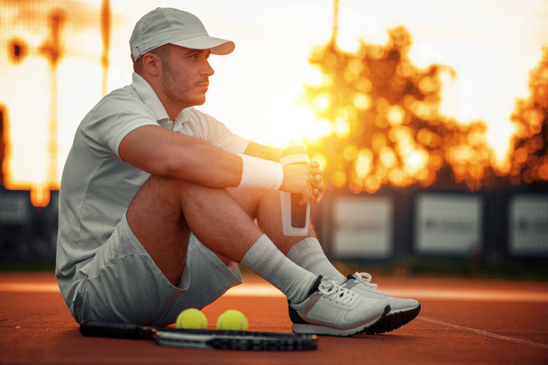 schöner Mann auf dem Tennisplatz: er hält Tennisschläger in der Hand. - Foto, Bild