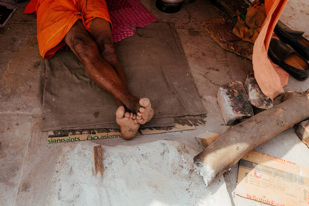 κομμένα φωτογραφία του άντρα με πορτοκαλί ρούχα που βρίσκονται στο πάτωμα - Φωτογραφία, εικόνα