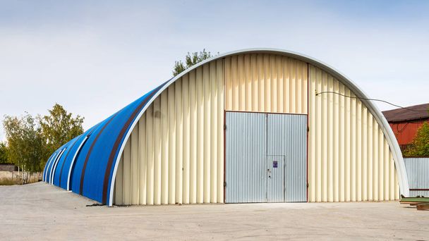 Facade of a blue metal warehouse, commercial building for storage of goods. The concept of storage of goods by importers, exporters, wholesalers, transport enterprises, customs - Photo, Image