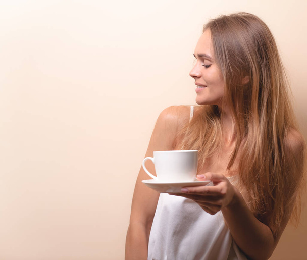 Jovem mulher desfrutando de uma xícara de café. Retrato de fêmea com chá da manhã. Espaço de cópia
 - Foto, Imagem