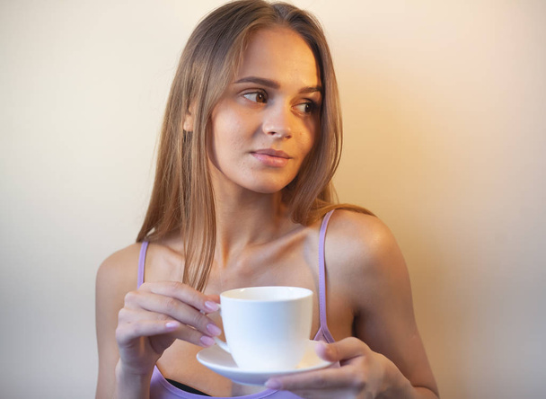 Молодая женщина наслаждается чашкой кофе. Портрет женщины с утренним чаем. Копирование пространства
 - Фото, изображение