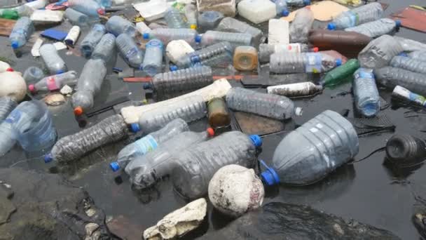 Milieuvervuiling. Plastic flessen, tassen, afval in de rivier, het meer. Vuilnis en vervuiling drijvend in water - Video