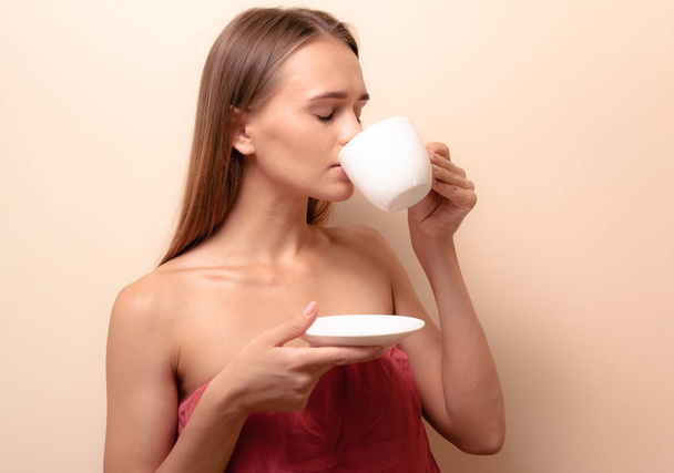 Young woman enjoying a cup of coffee. Portrait of female with morning tea. Copy space - Foto, Bild