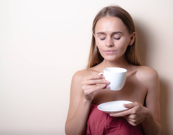 Jovem mulher desfrutando de uma xícara de café. Retrato de fêmea com chá da manhã. Espaço de cópia
 - Foto, Imagem