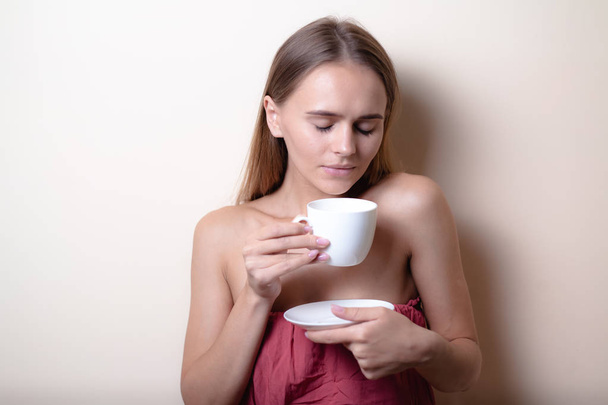 Fiatal nő élvezi egy csésze kávét. Portré nő a reggeli tea. Lemezterület másolása - Fotó, kép