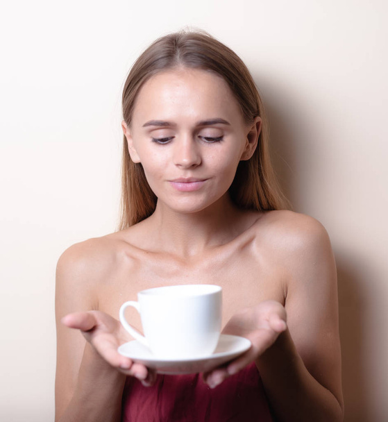 junge Frau bei einer Tasse Kaffee. Frauenporträt mit Morgentee. Kopierraum - Foto, Bild