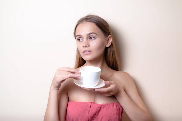 Young woman enjoying a cup of coffee. Portrait of female with morning tea. Copy space - Zdjęcie, obraz
