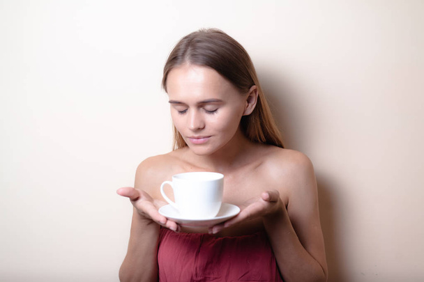 Mujer joven disfrutando de una taza de café. Retrato de mujer con té de la mañana. Copiar espacio
 - Foto, imagen