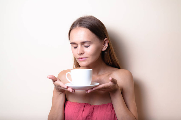 Mujer joven disfrutando de una taza de café. Retrato de mujer con té de la mañana. Copiar espacio
 - Foto, Imagen