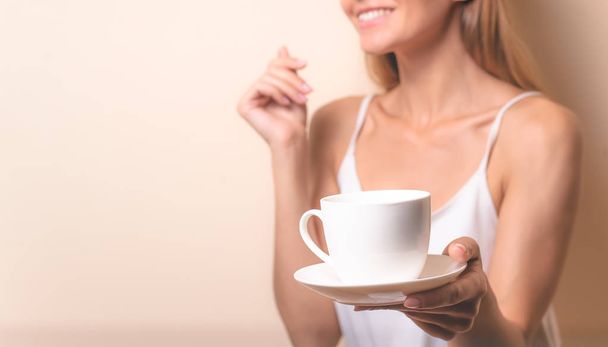 Une jeune femme qui prend une tasse de café. Portrait de femme avec thé du matin. Espace de copie
 - Photo, image