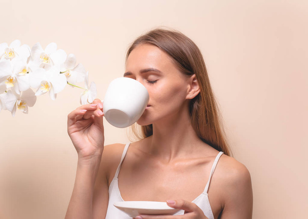 Young woman enjoying a cup of coffee. Portrait of female with morning tea. Copy space - Foto, afbeelding