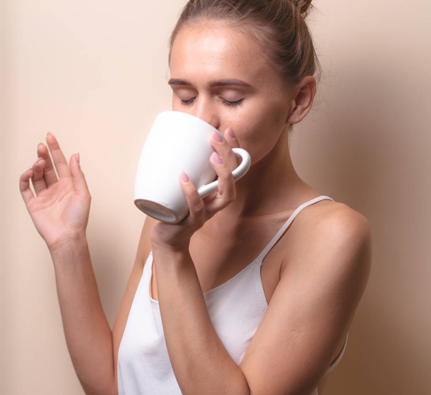 Молода жінка насолоджується чашкою кави. Портрет самки з ранковим чаєм. Копіювати простір
 - Фото, зображення