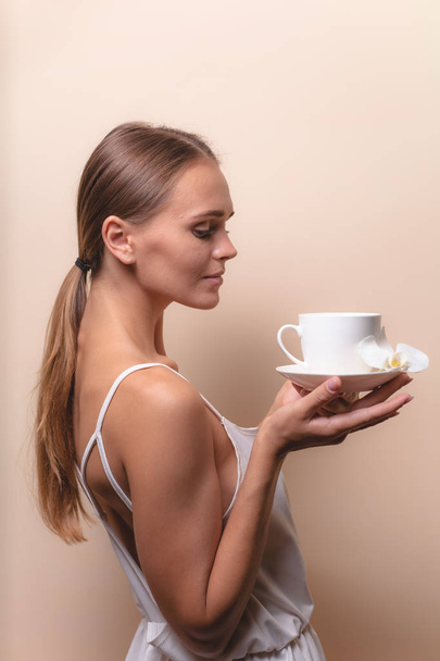 Μια νεαρή γυναίκα που απολαμβάνει ένα φλιτζάνι καφέ. Πορτραίτο θηλυκού με πρωινό τσάι. Αντιγραφή χώρου - Φωτογραφία, εικόνα