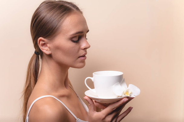 Jonge vrouw genieten van een kopje koffie. Portret van vrouw met ochtendthee. Ruimte kopiëren - Foto, afbeelding