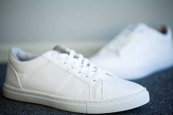 Dvojice nových stylových bílých tenisky na podlaze doma - Fotografie, Obrázek